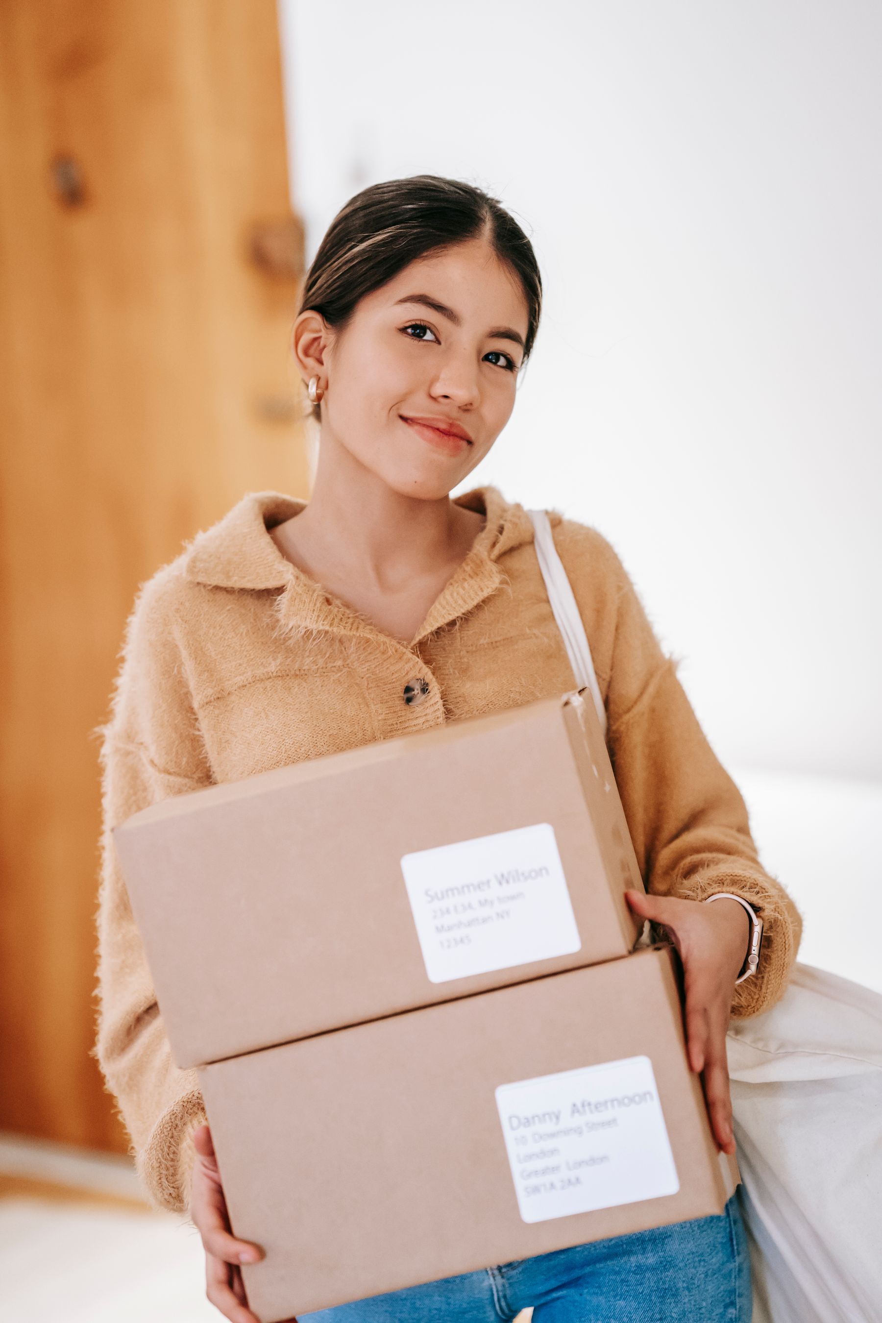 A smiling woman holding her delivered packages at home